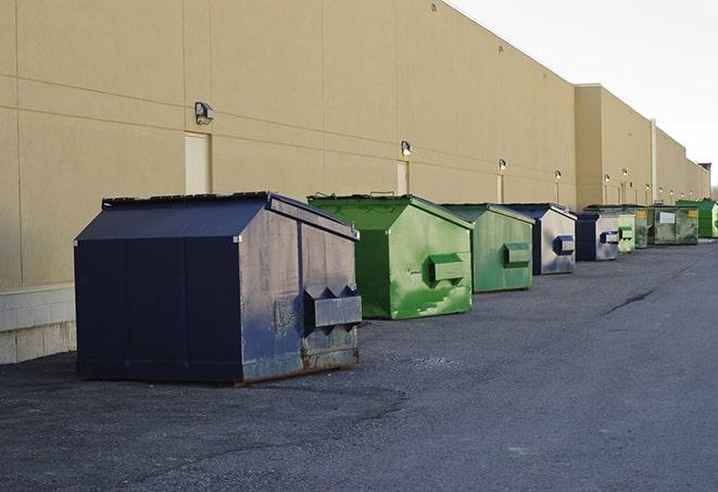 a construction worker empties a wheelbarrow of waste into the dumpster in Hainesville IL